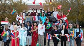 国际学生在米切尔中心前举着旗帜